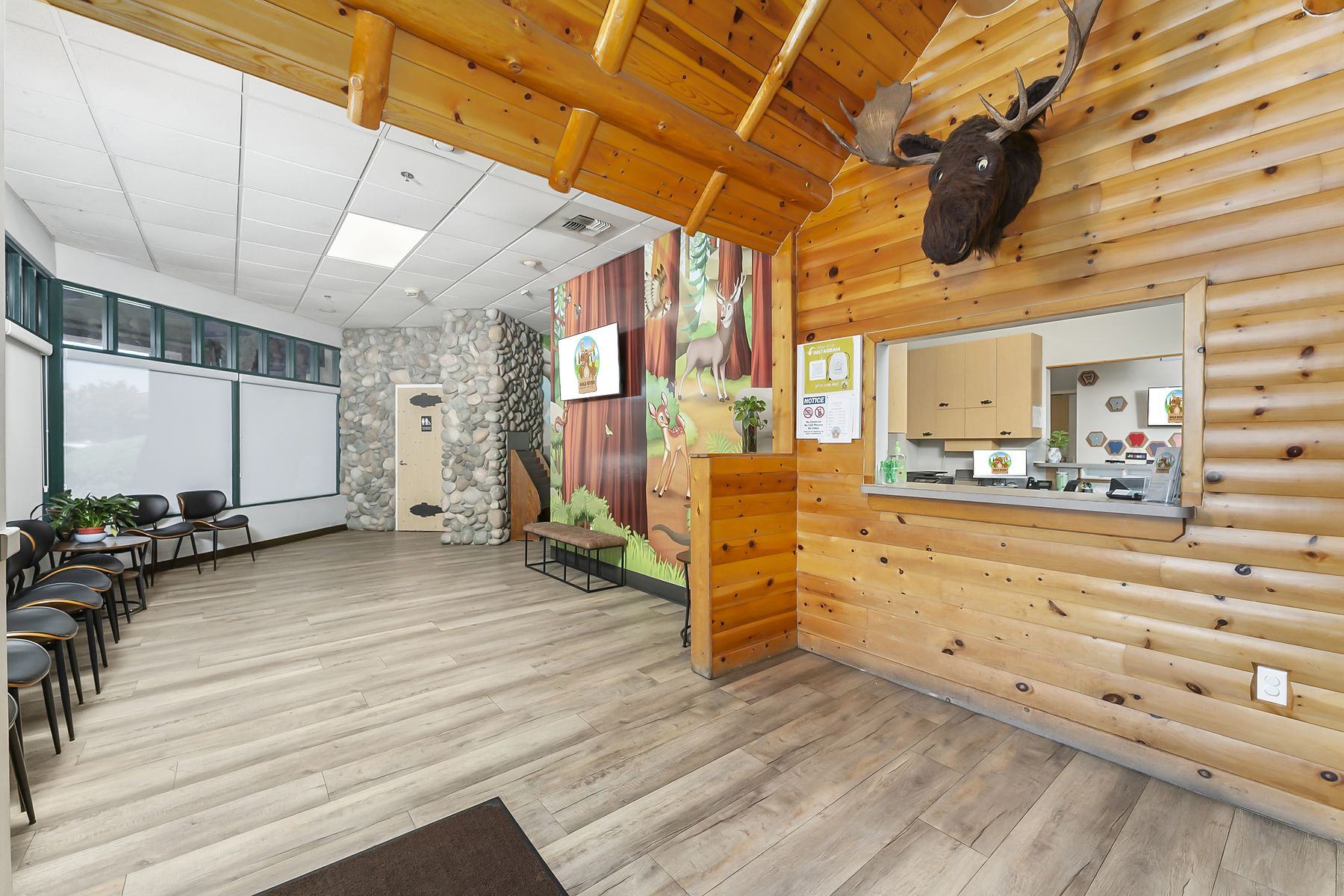 Log-beam cabin front and check-in window at the head of our waiting room