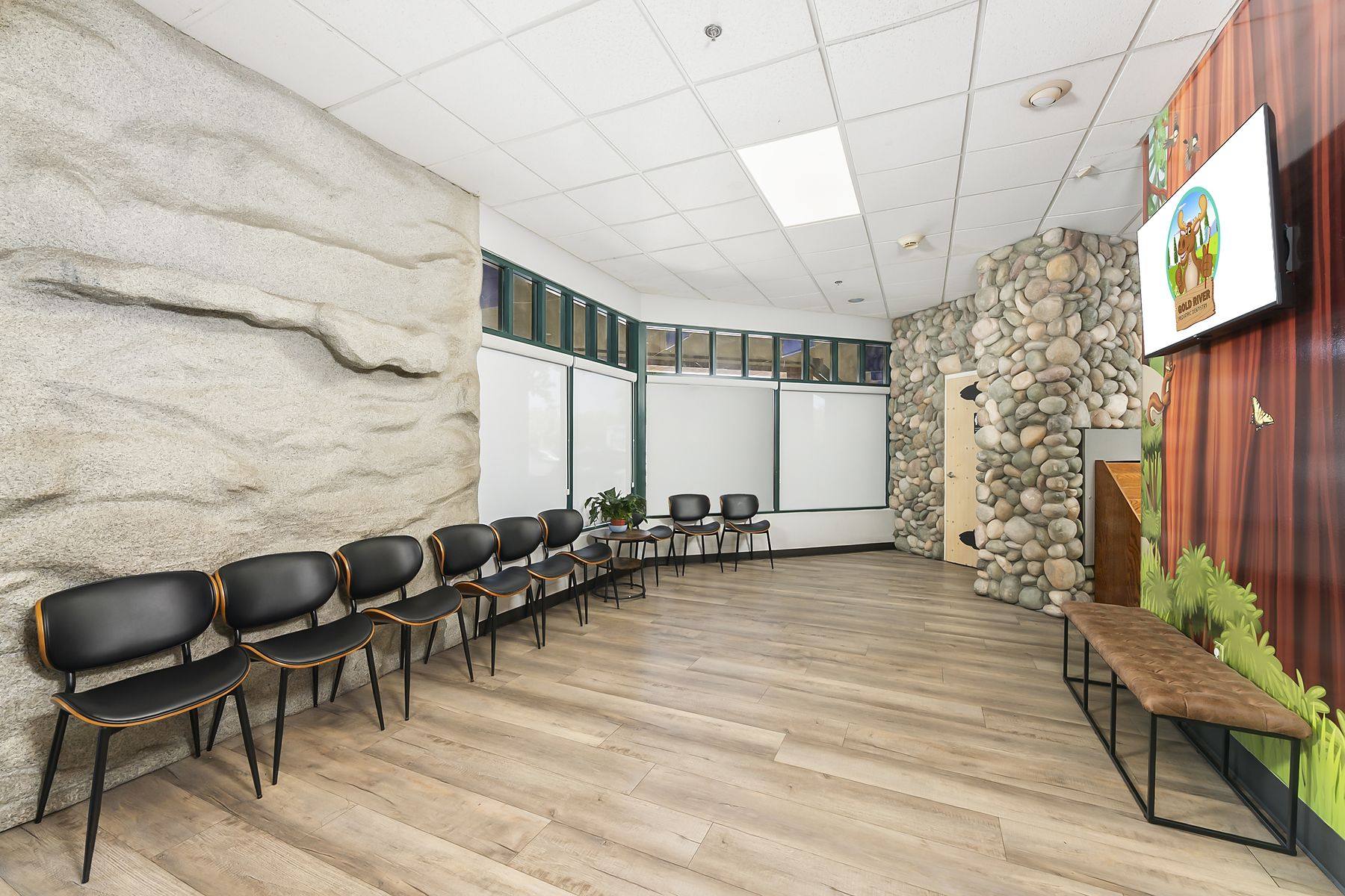 Waiting room with a granite rock wall and a leather bench