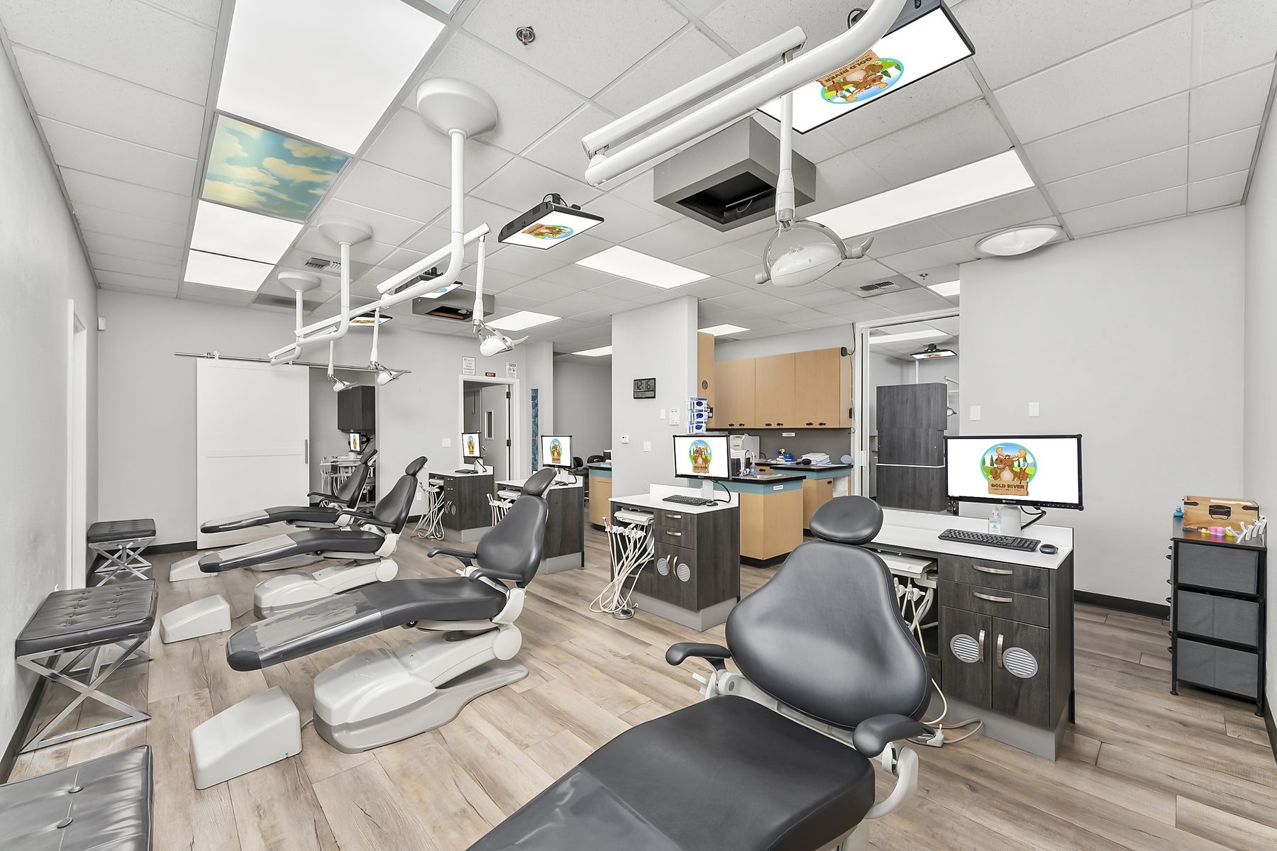 Treatment bay with chairside monitors and the sterilization area behind
